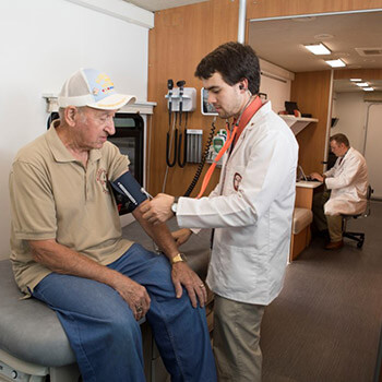 Student performing blood pressure check.